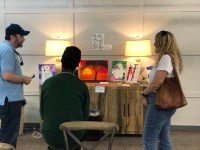 Artists Rico Sharpe discussing his art with potential buyers.